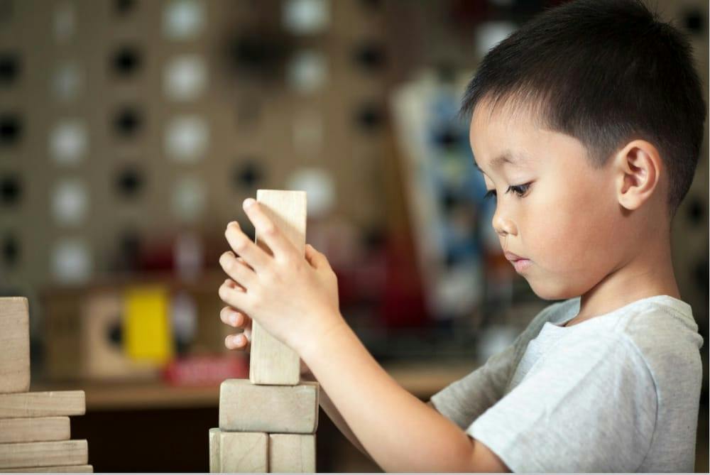 Child stacking wooden blocks