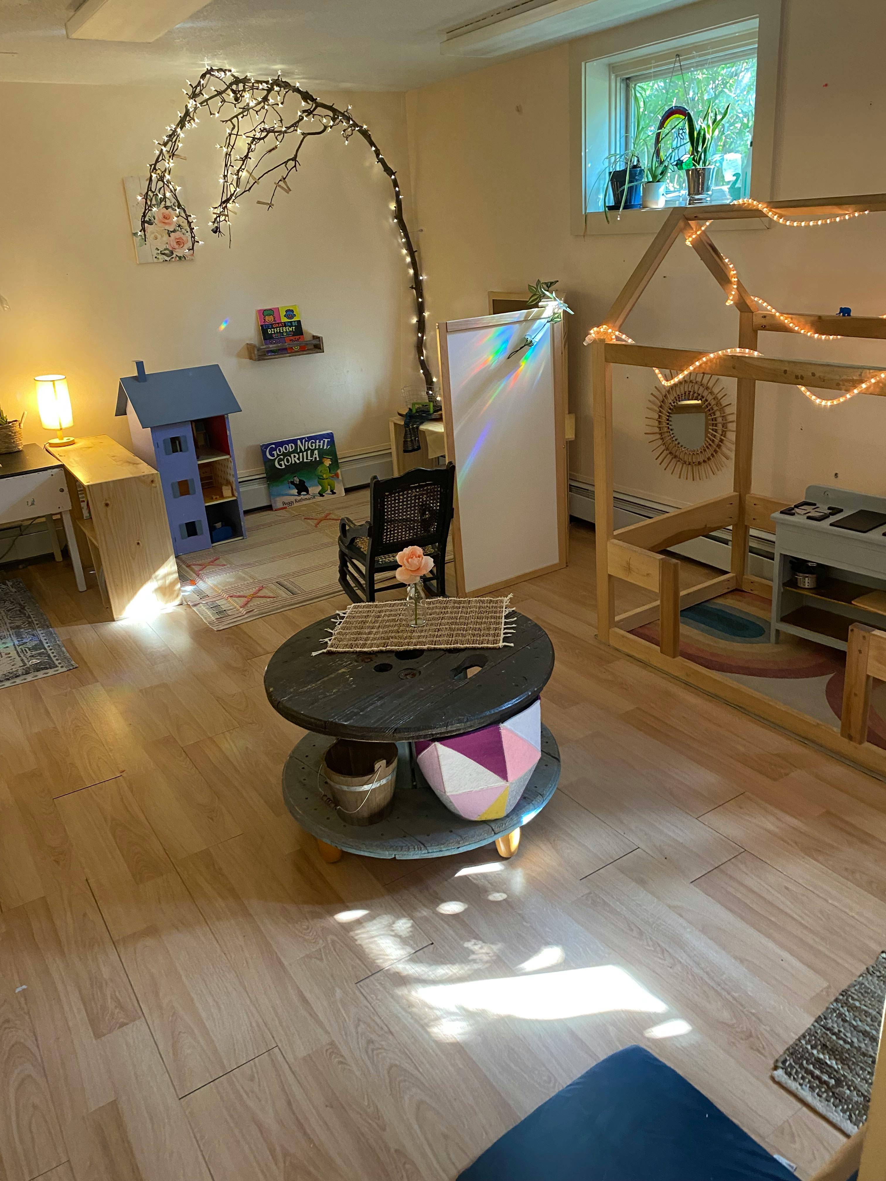Playroom with wooden furniture, dollhouse, and string lights