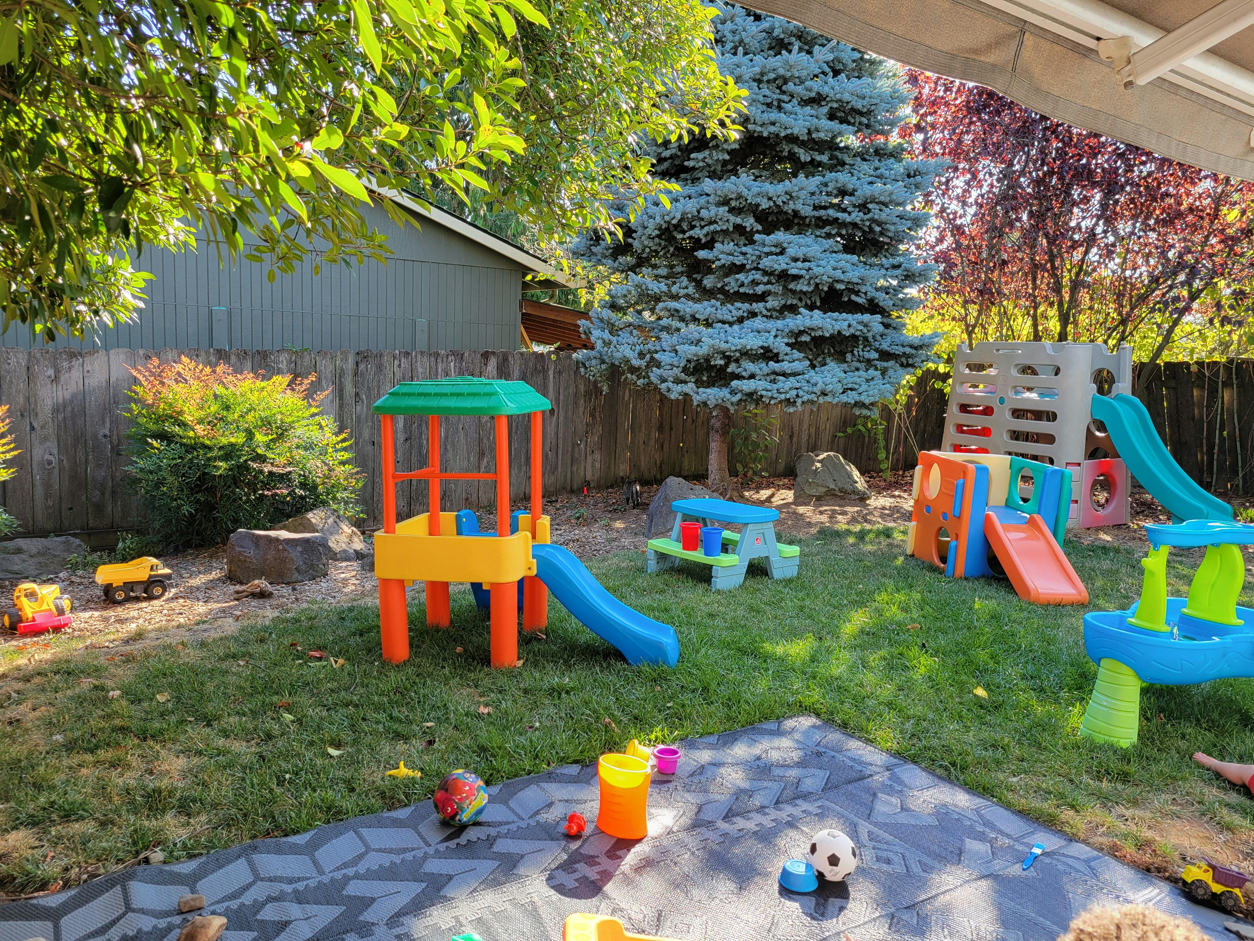 Children's outdoor play area with multiple slides, play structures, and toys
