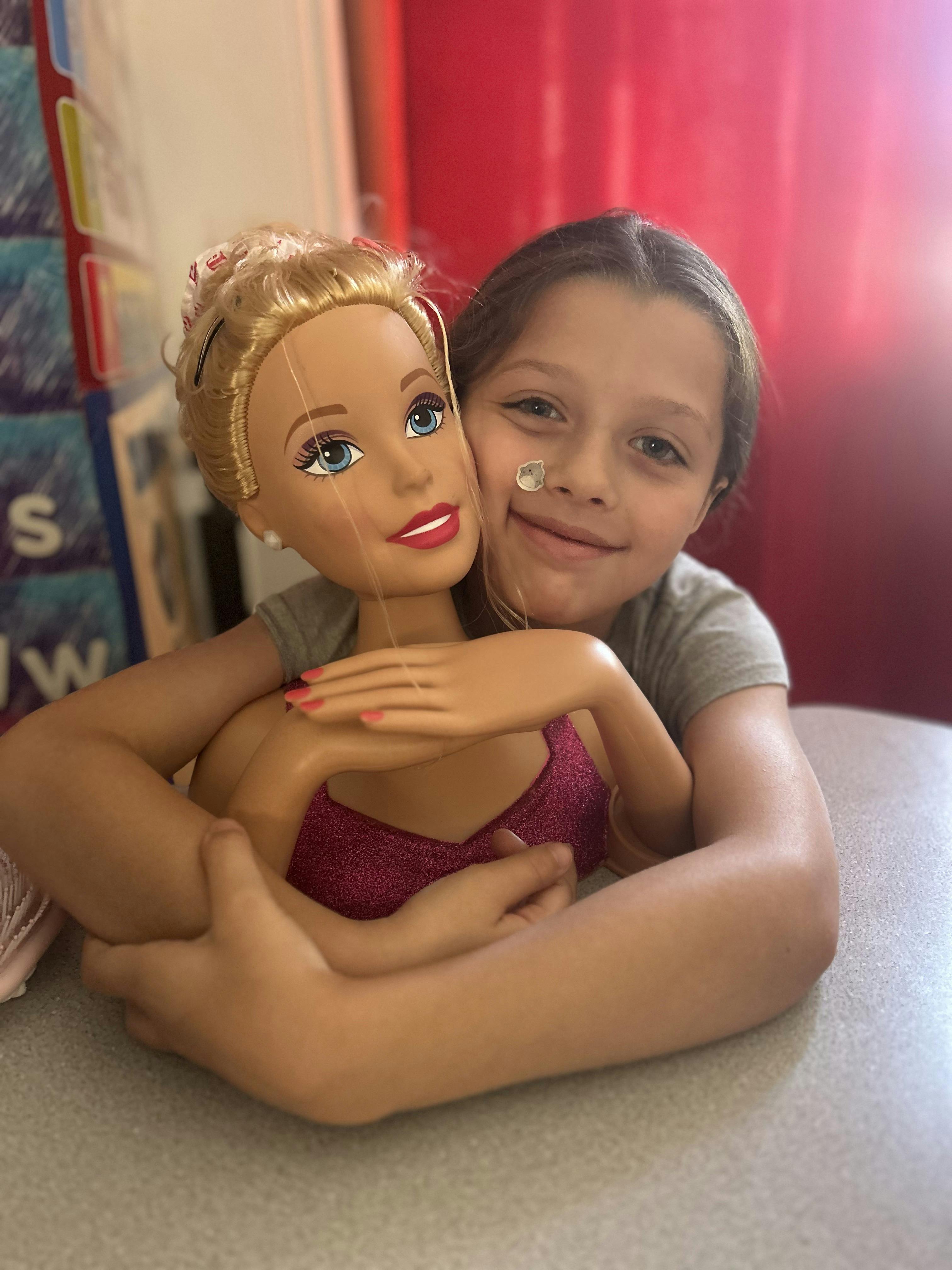 Child hugging a large doll