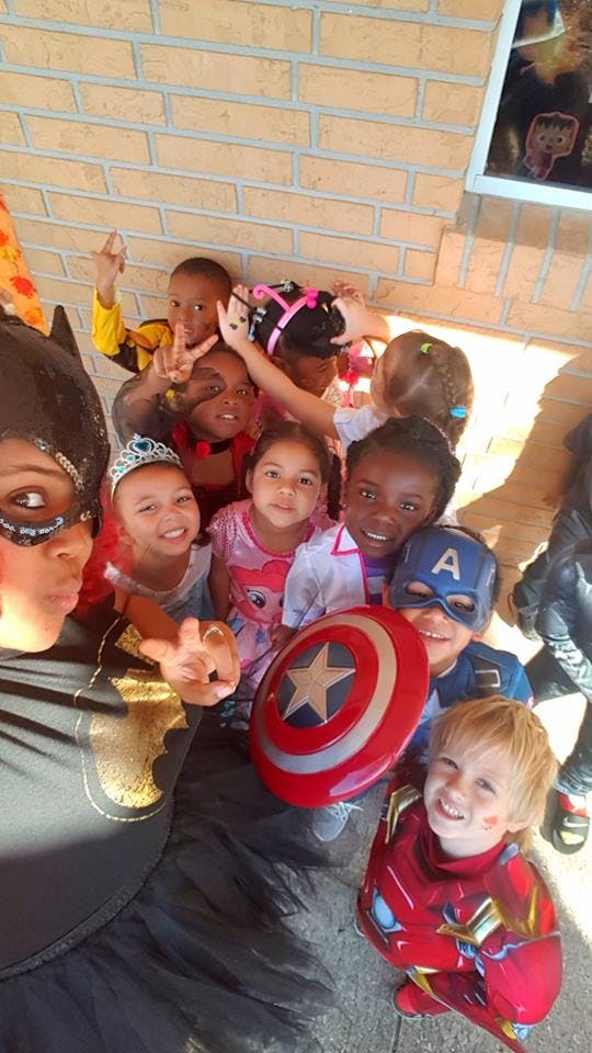 Group of children in costumes, one holding a Captain America shield