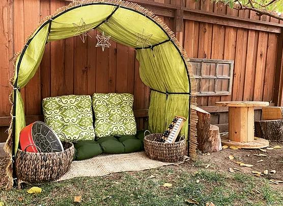 Outdoor seating area with green cushions under a fabric canopy