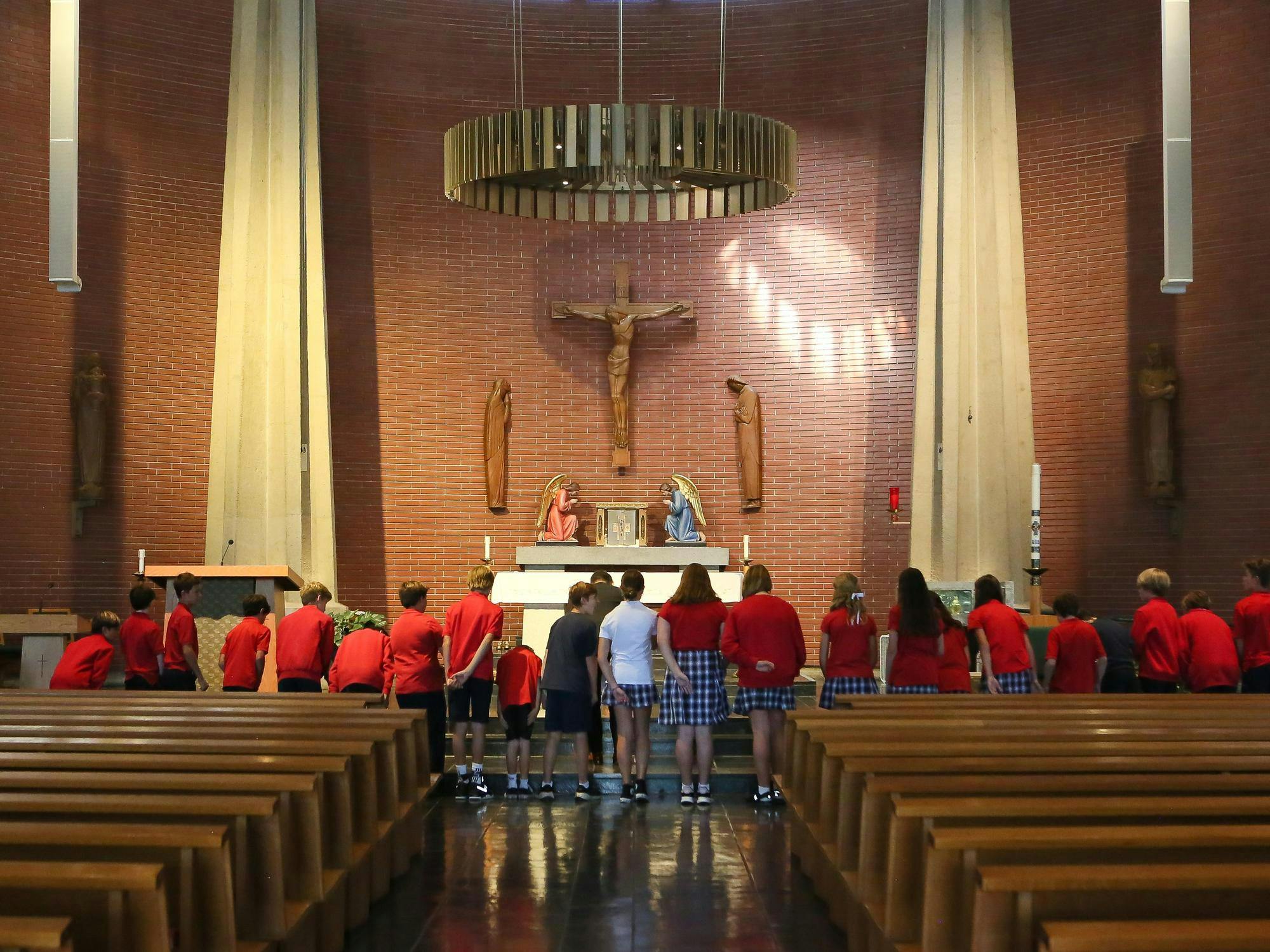 Group of children standing in a church looking toward the altar