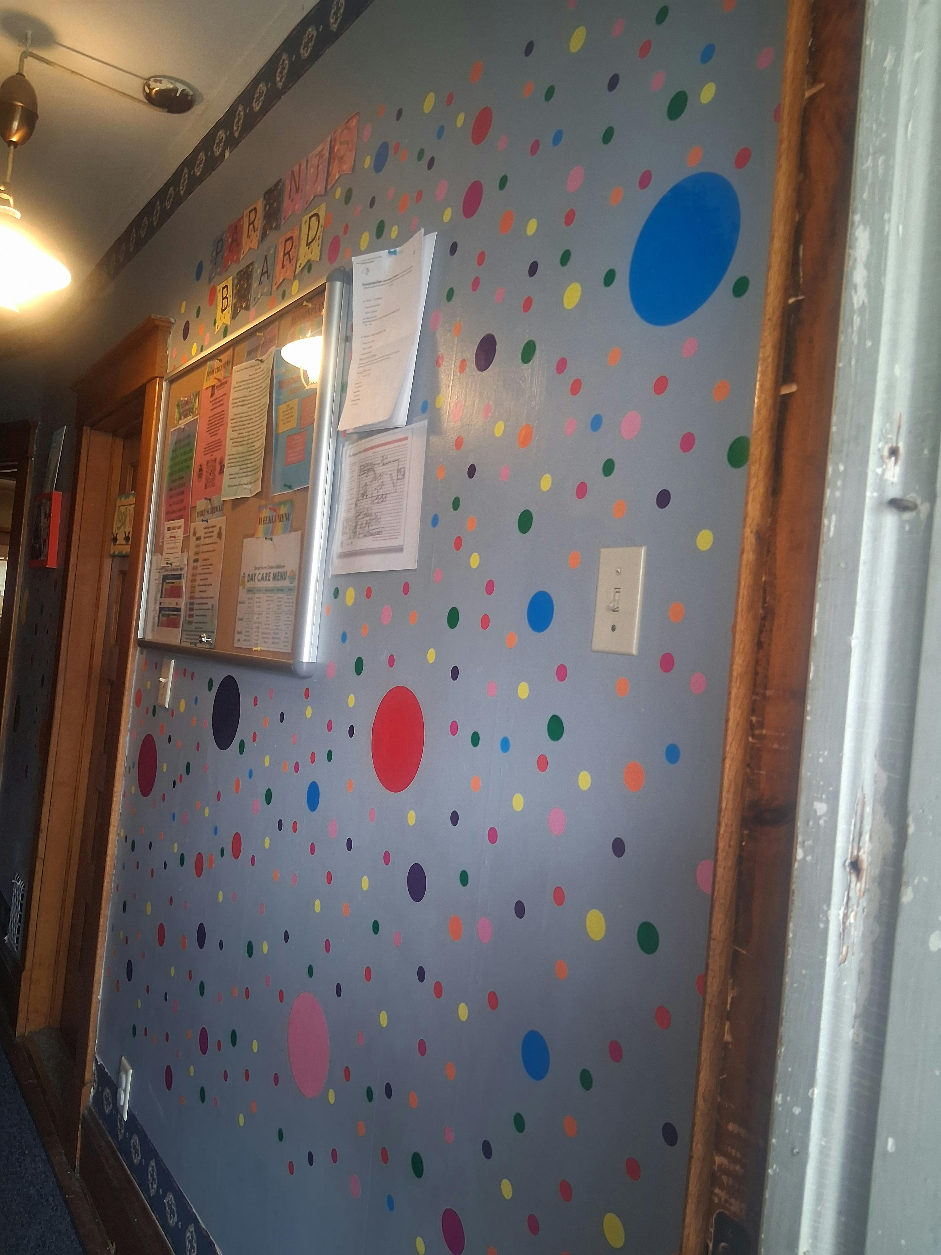 Wall with colorful polka dots and a bulletin board