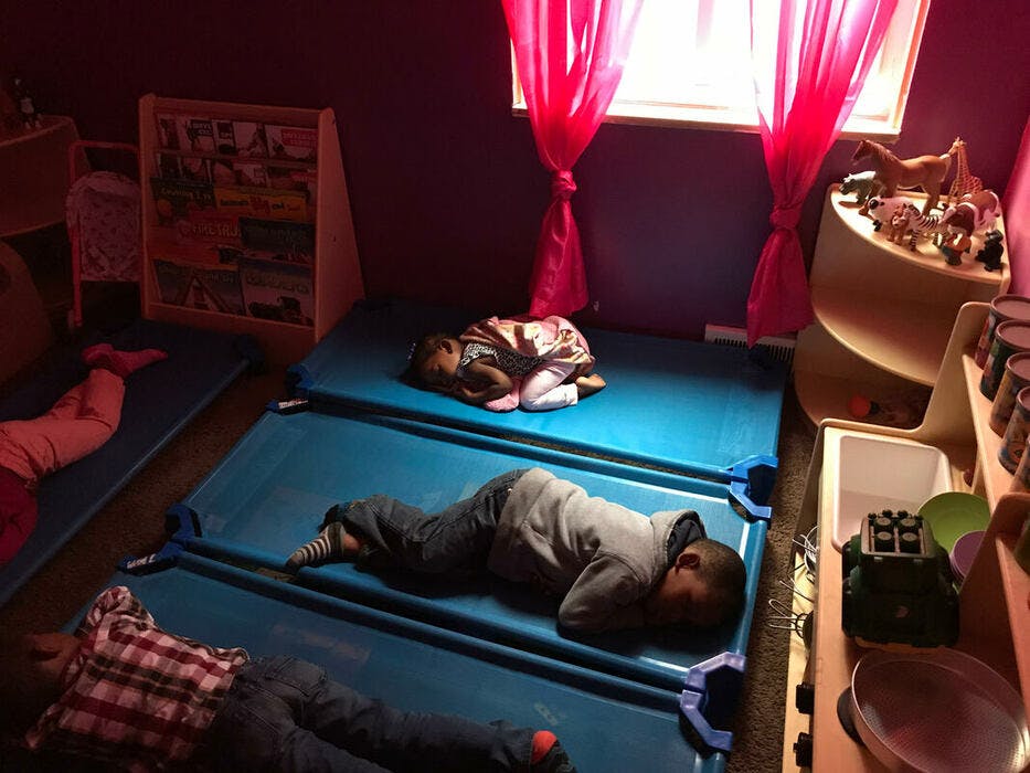 Children sleeping on cots in a room