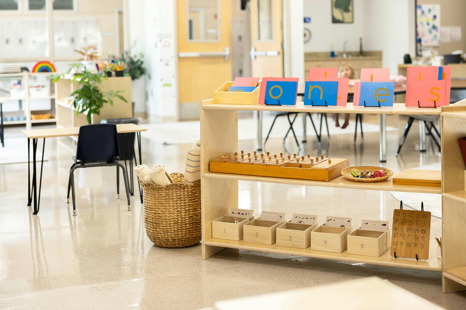 Wooden shelf in a classroom featuring letter cards and educational materials