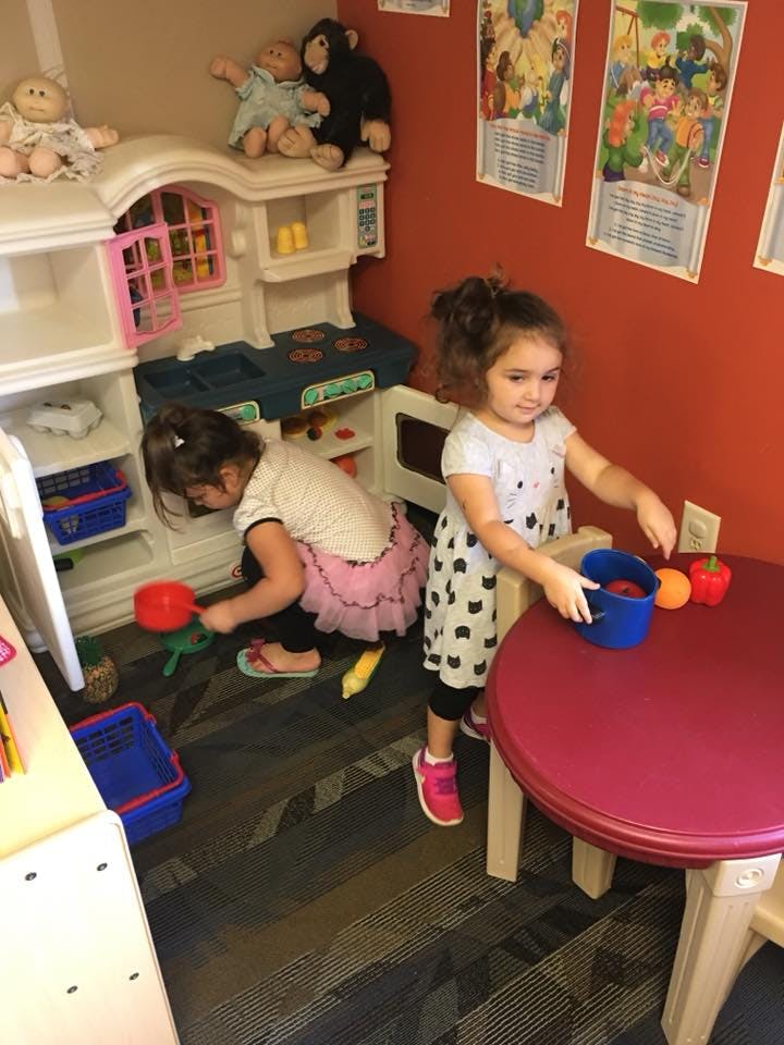Two children playing with toys in a room