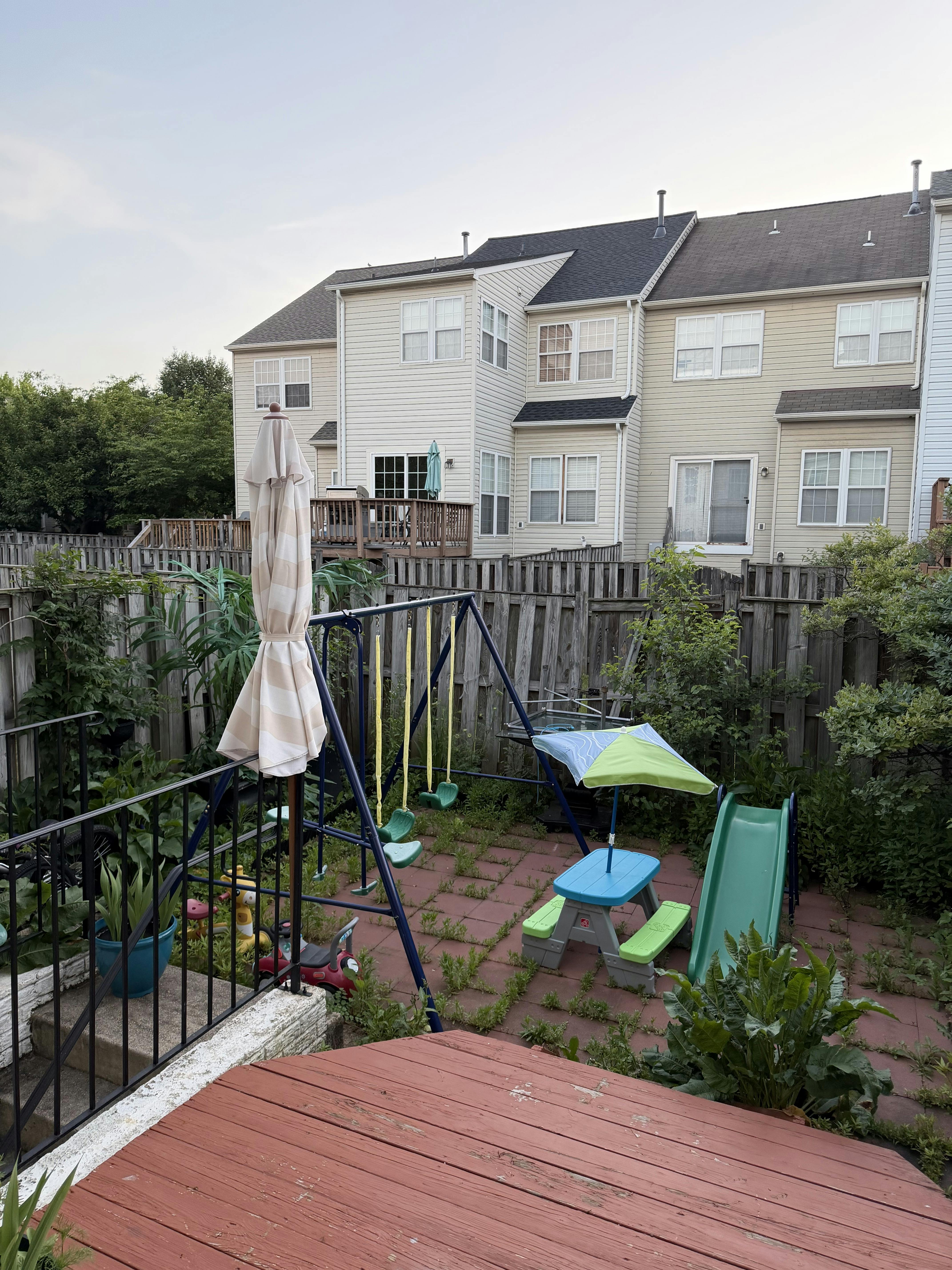 backyard with swing set, picnic table, slide, and a wooden fence