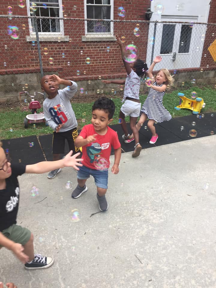 Children playing with bubbles outdoors