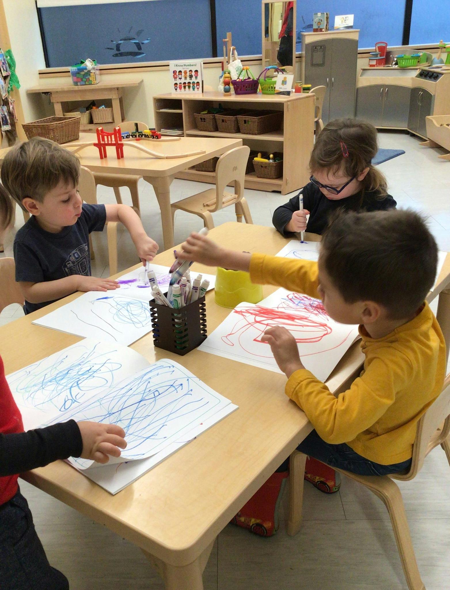 Children drawing at a table in a classroom