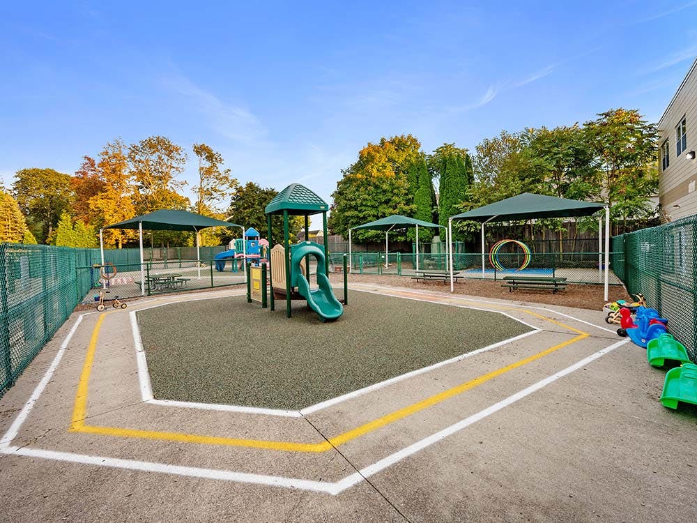 Outdoor playground area with play structures and shaded seating