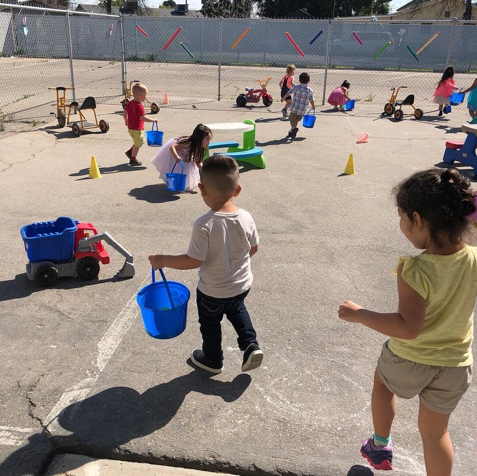 Children playing with buckets and toys outdoors