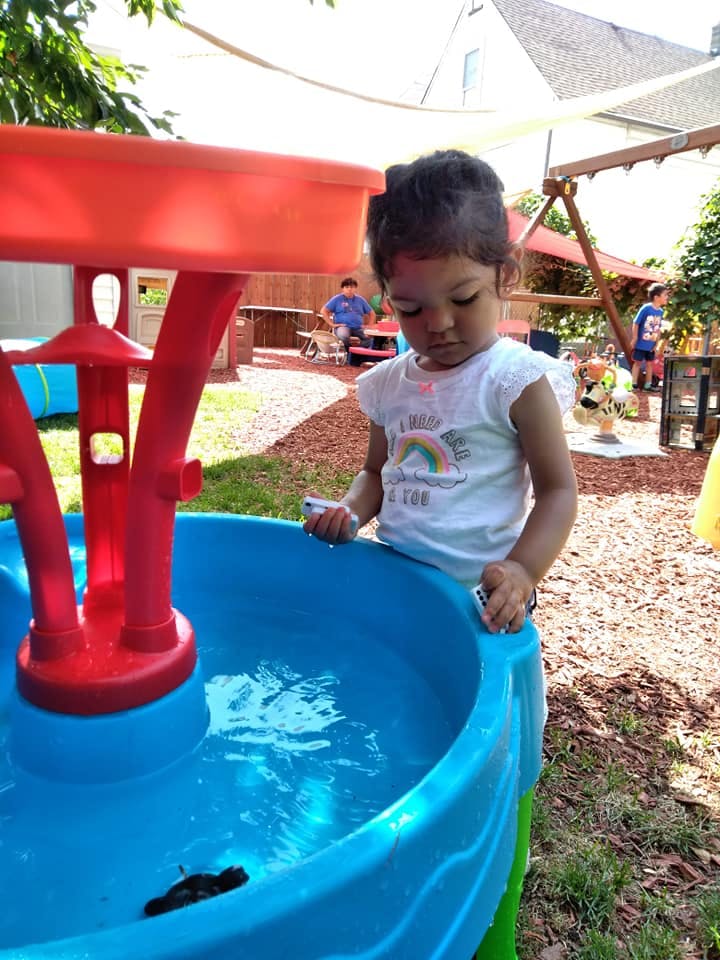 Child playing with a water table outdoors
