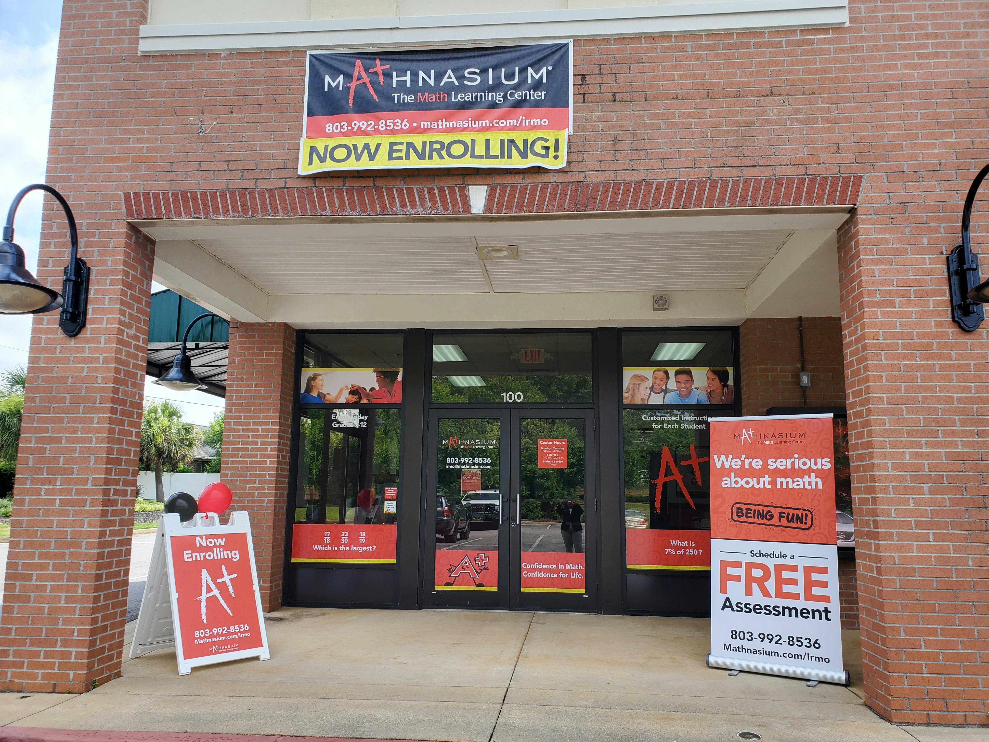 Mathnasium learning center entrance with signs and banners reading "NOW ENROLLING!"