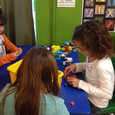 Children playing with building blocks at a table