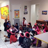 Adults and children sitting on the floor in a room