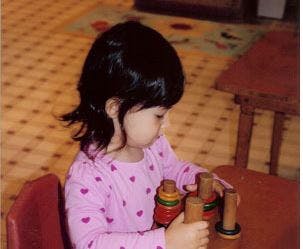 Child playing with stacking rings at a table