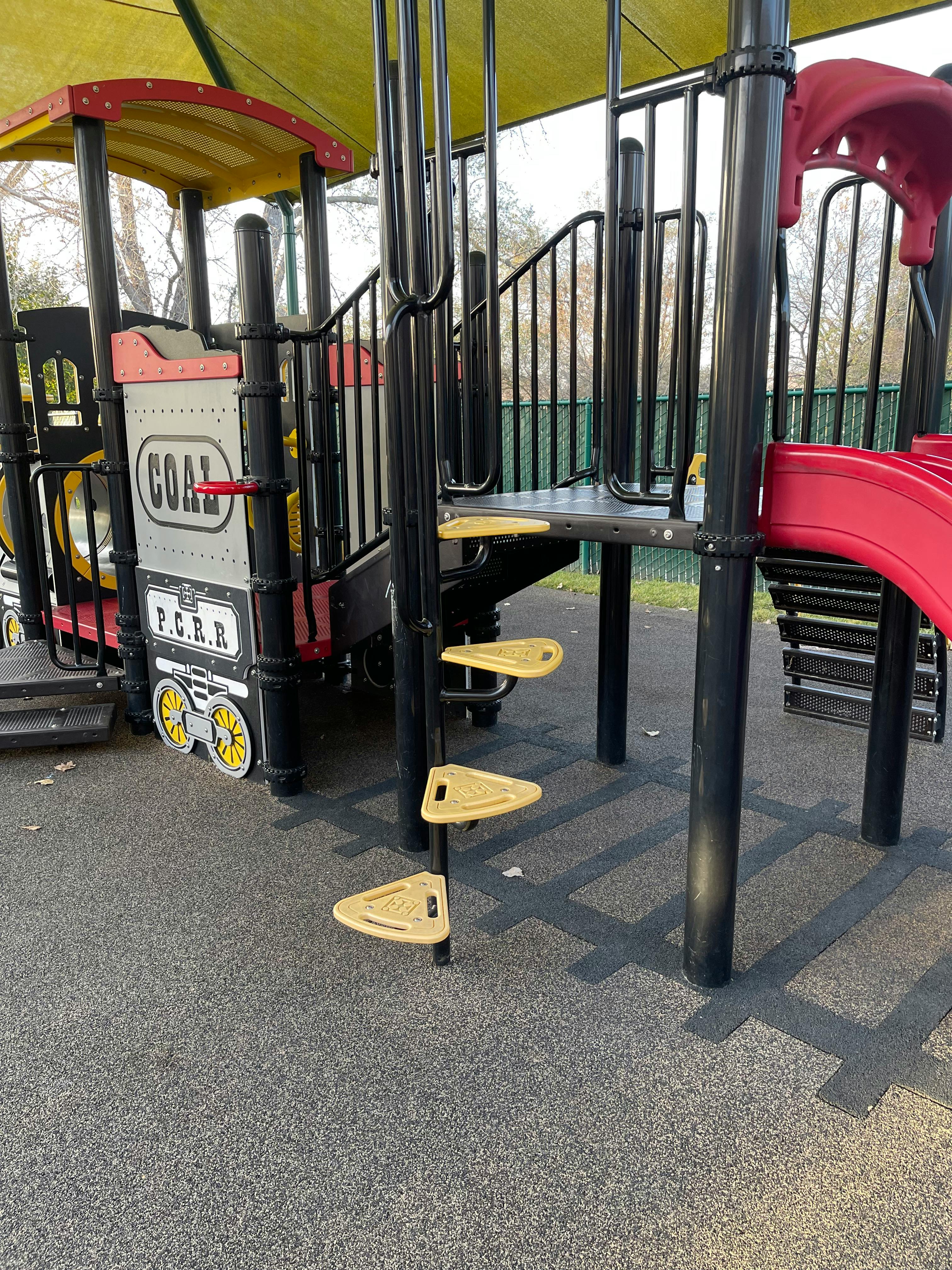 Playground structure with a train-shaped section and spiral steps