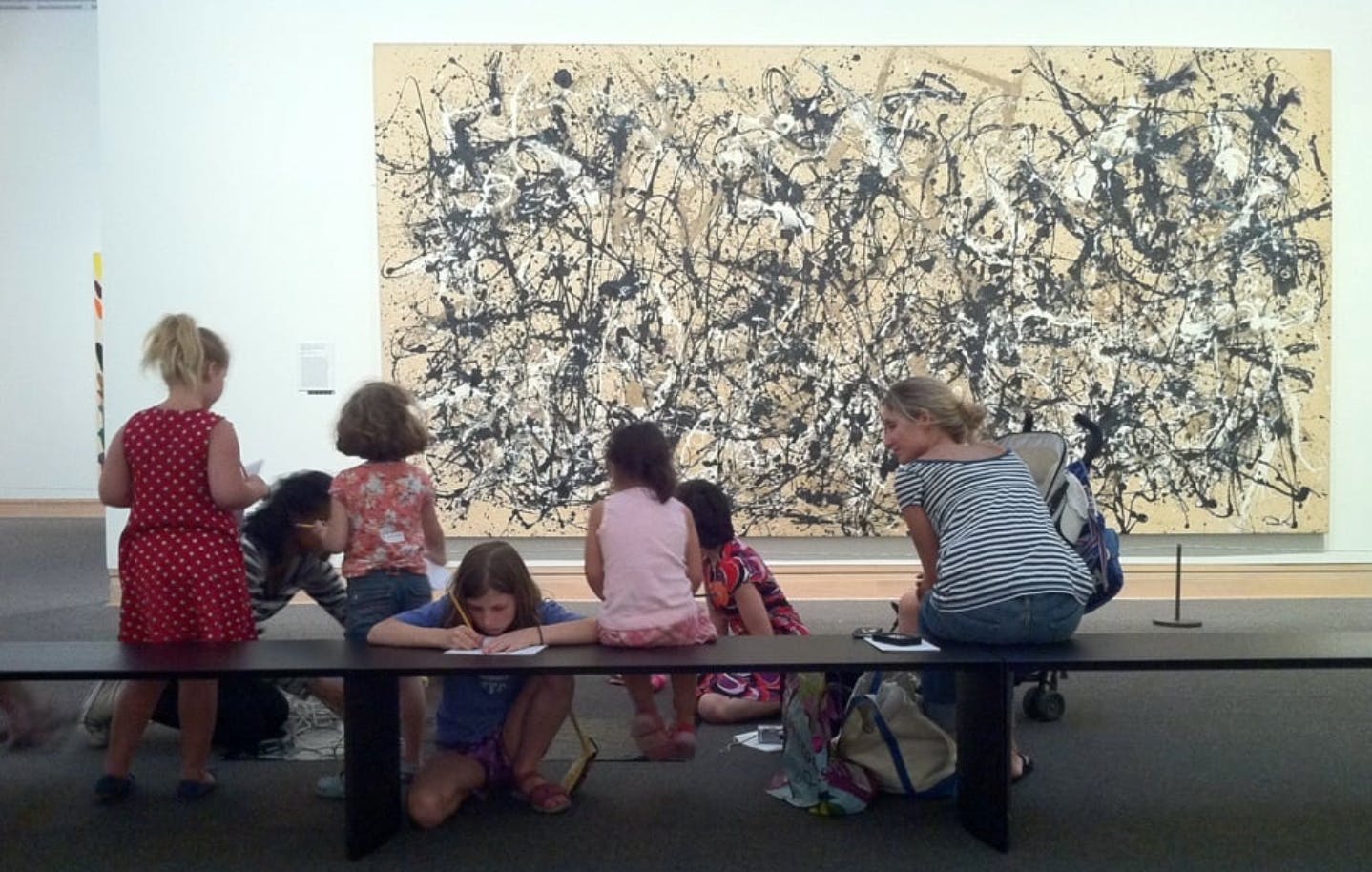 Children and adults looking at a large abstract painting in a museum