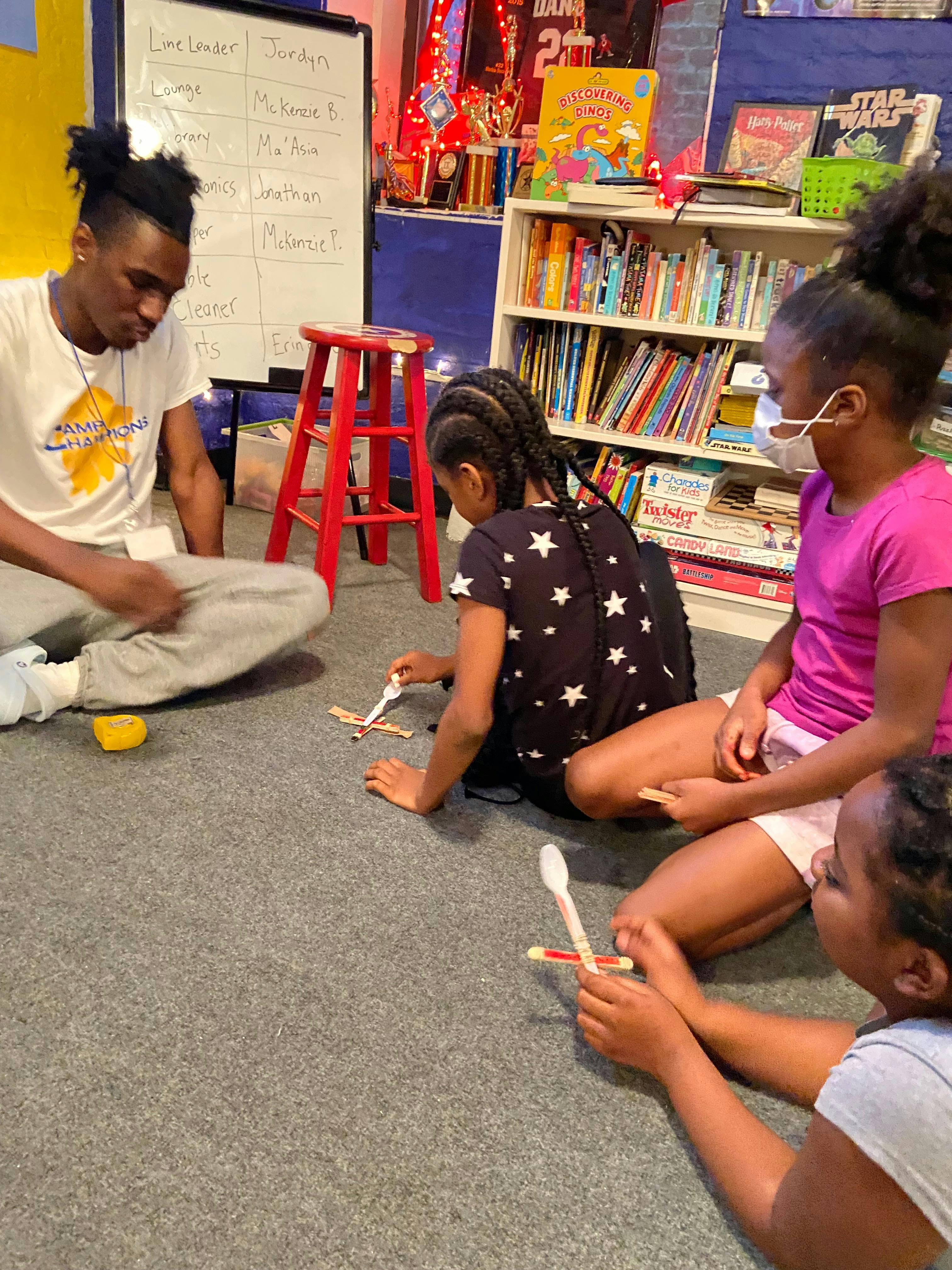 Adult and children sitting on floor making crafts