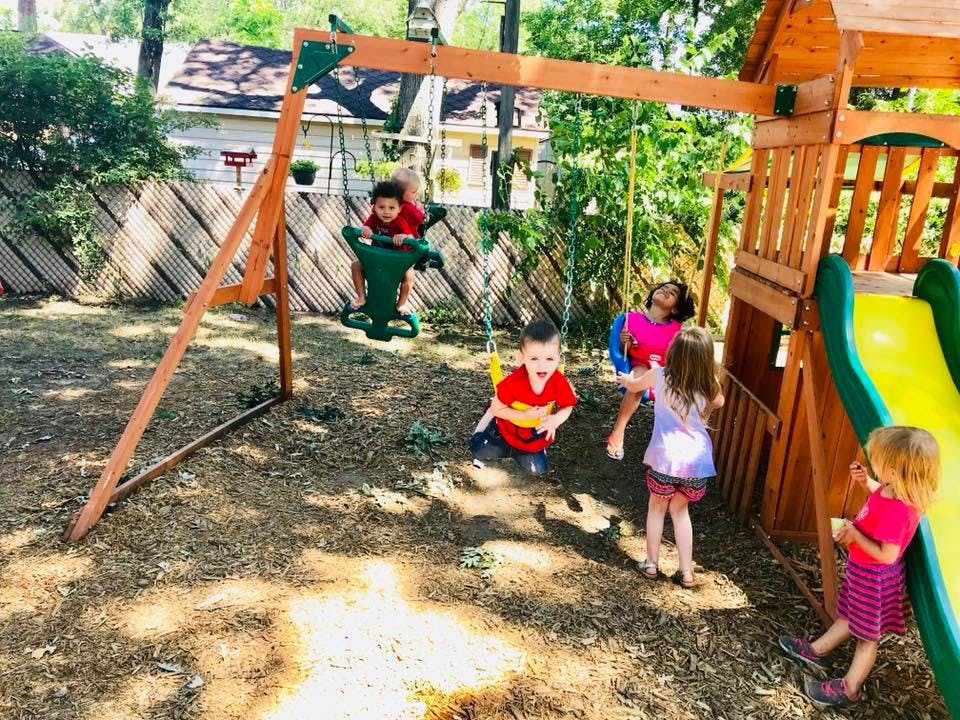 Children playing on a swing set and playground slide
