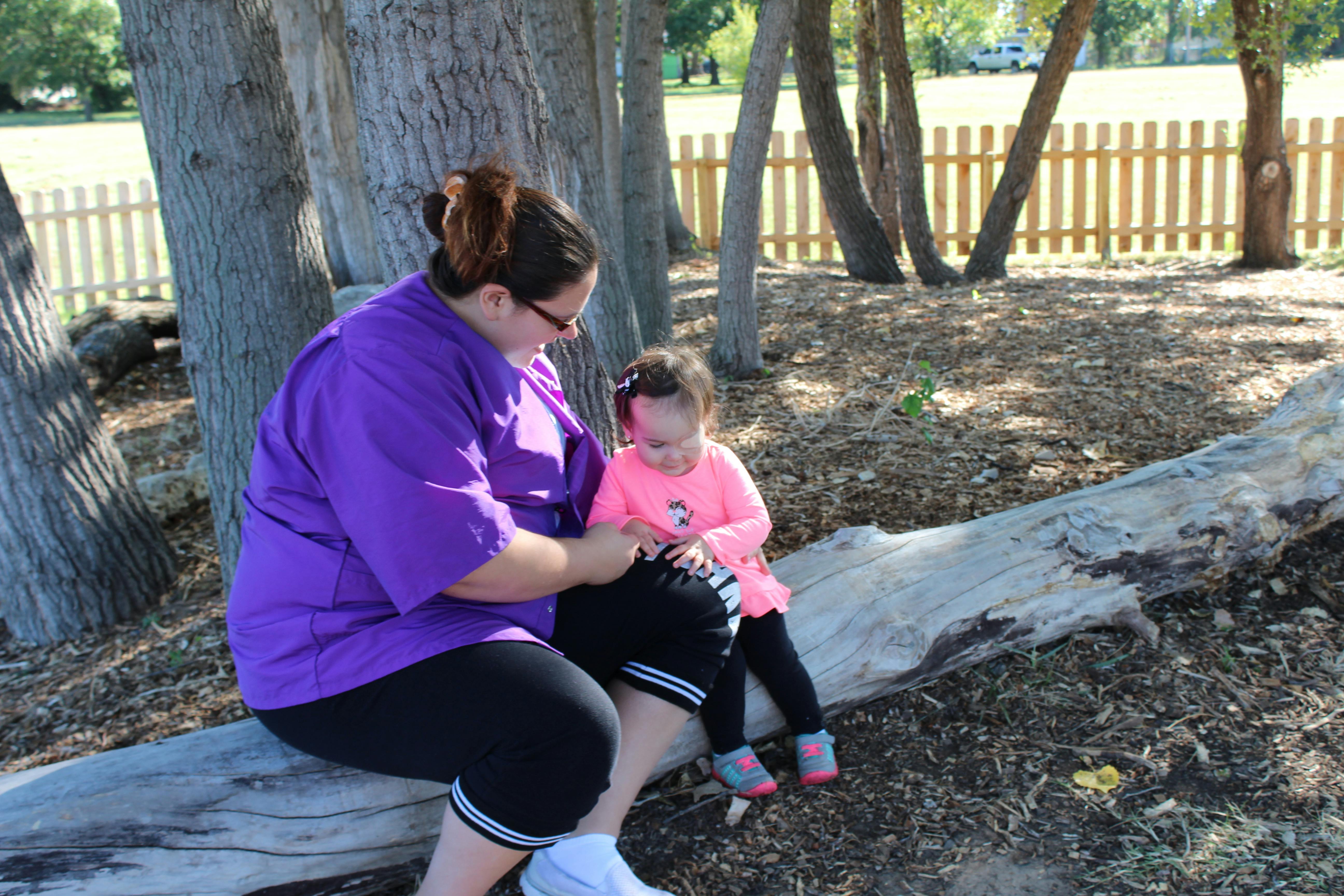Person and child sitting on a log