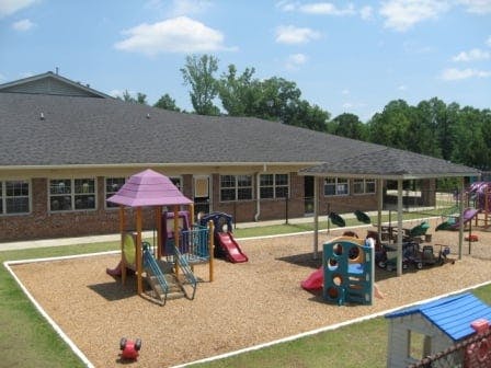 Playground with slides and play structures next to a building