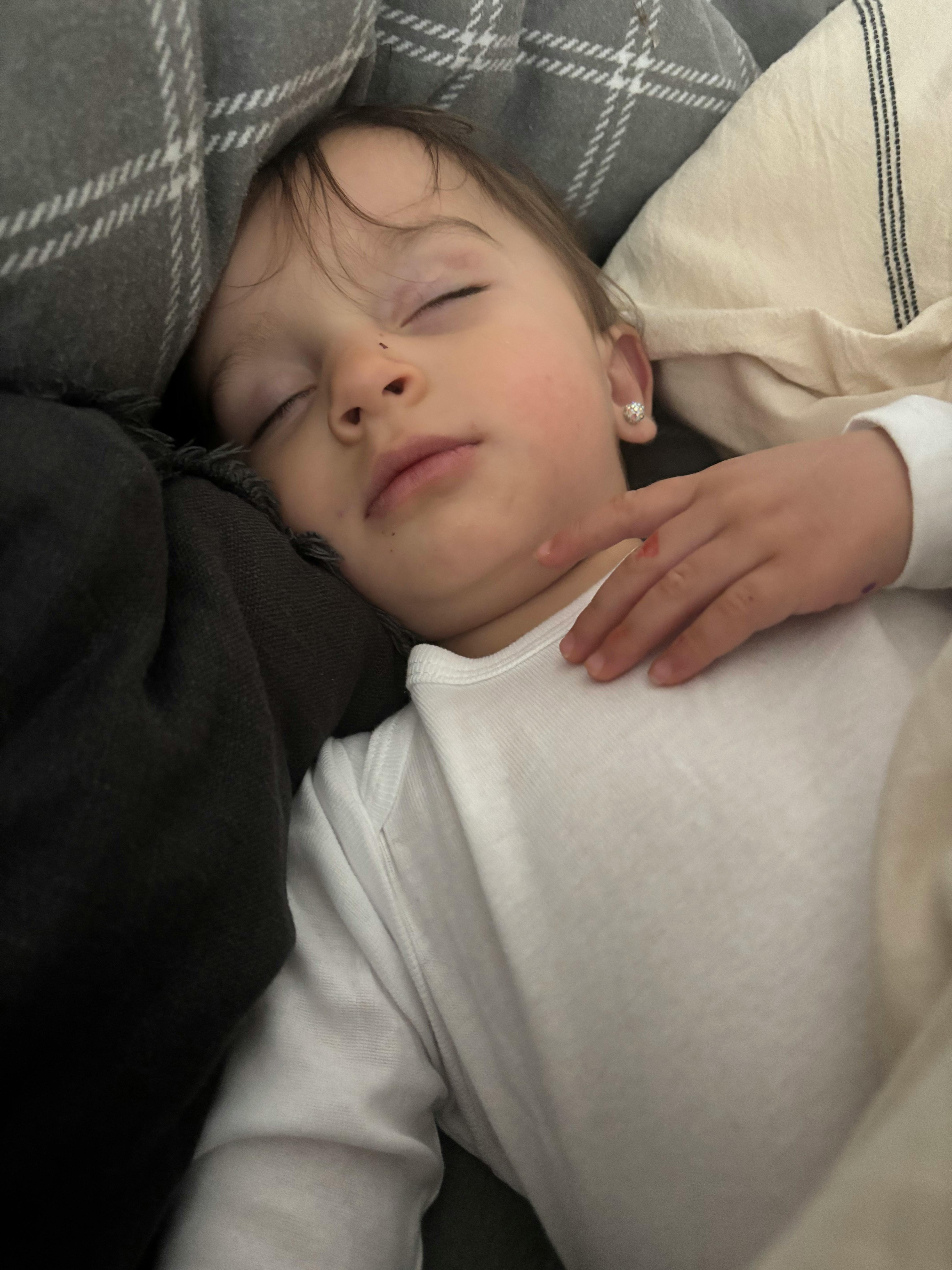 Child sleeping with a hand resting on their chest