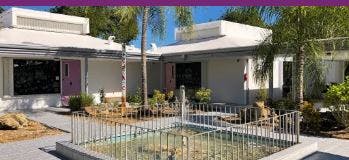 Building with a pink door and a small pool in the foreground