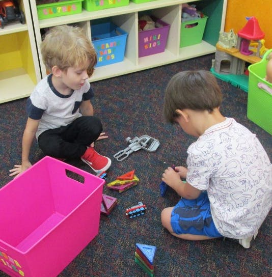 Two children playing with toys on the floor