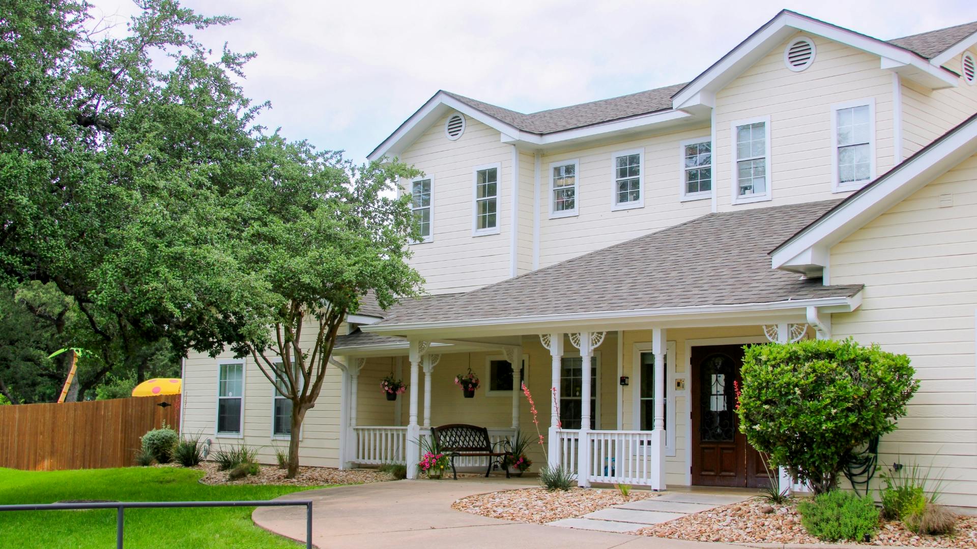 Large house with a front porch and trees