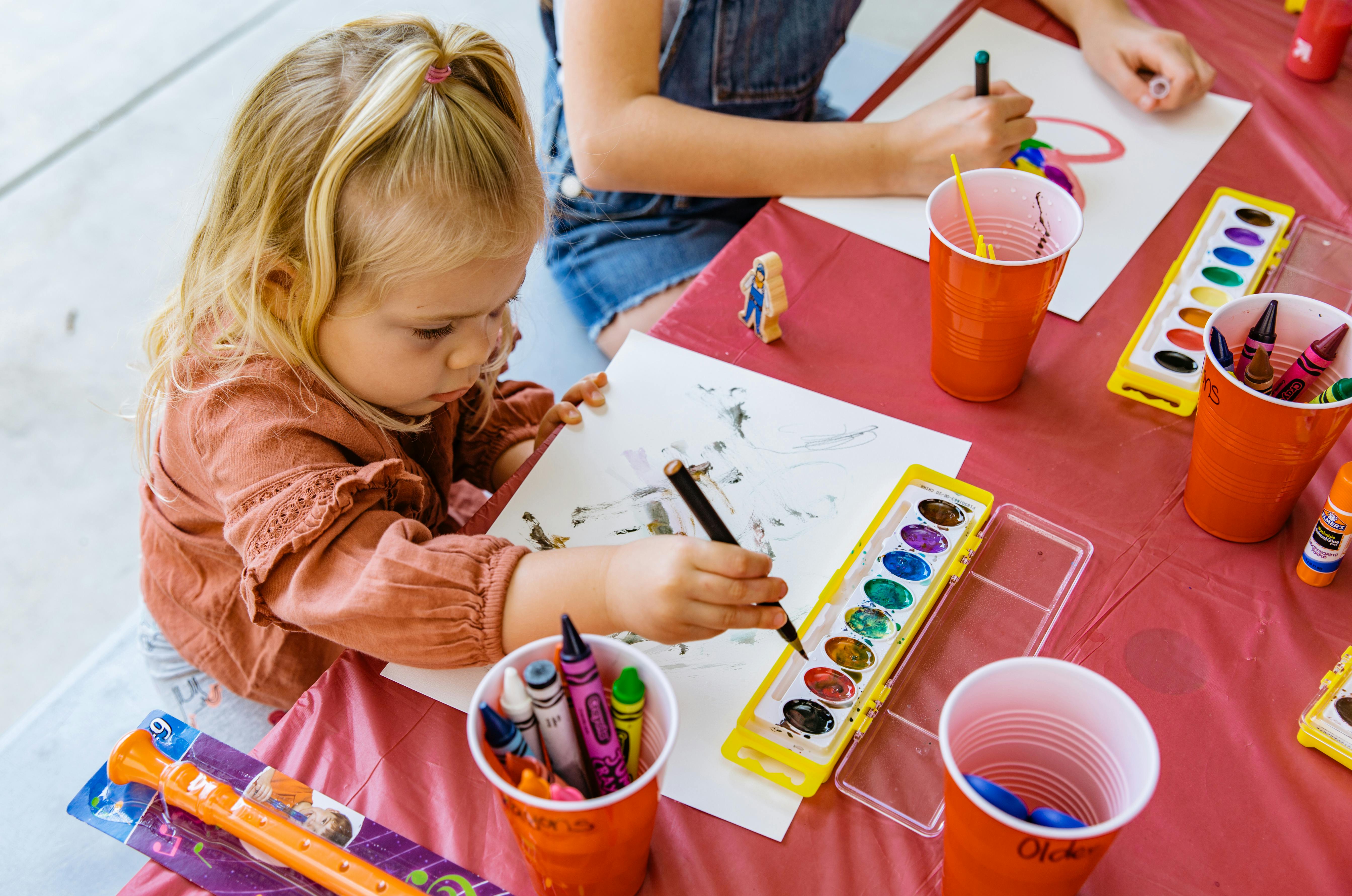 Child painting with watercolors at a table