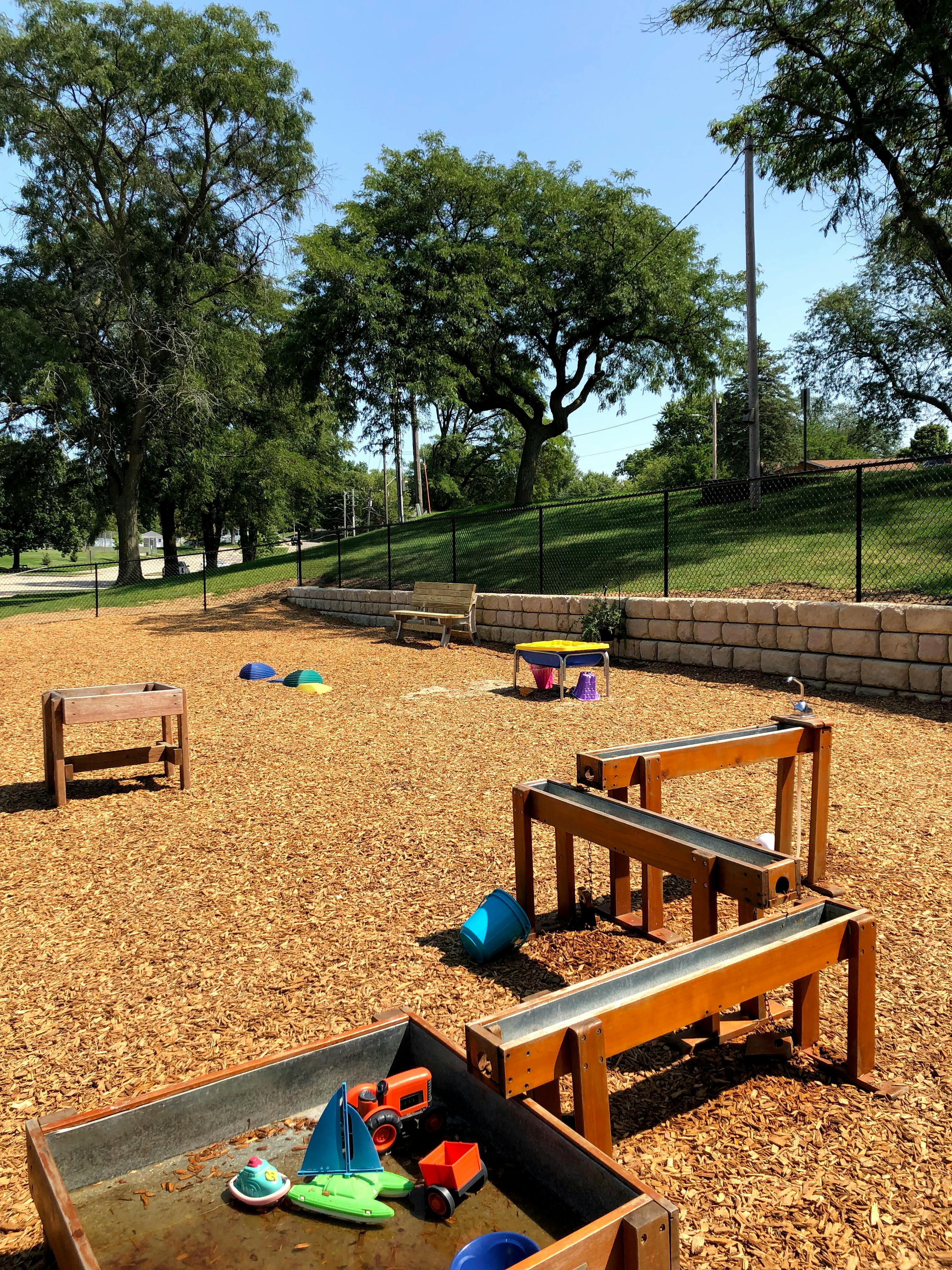 Outdoor play area with wooden water tables and toys