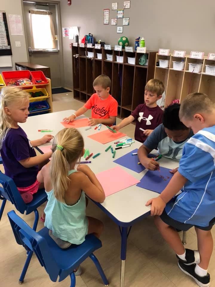 Children drawing at a table in a classroom