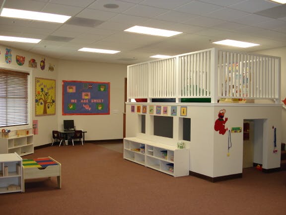 Playroom with a lofted play area and small tables