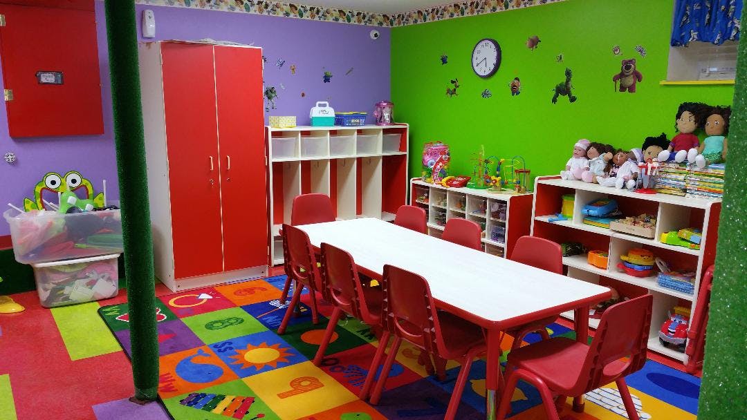 Classroom with a long white table and red chairs