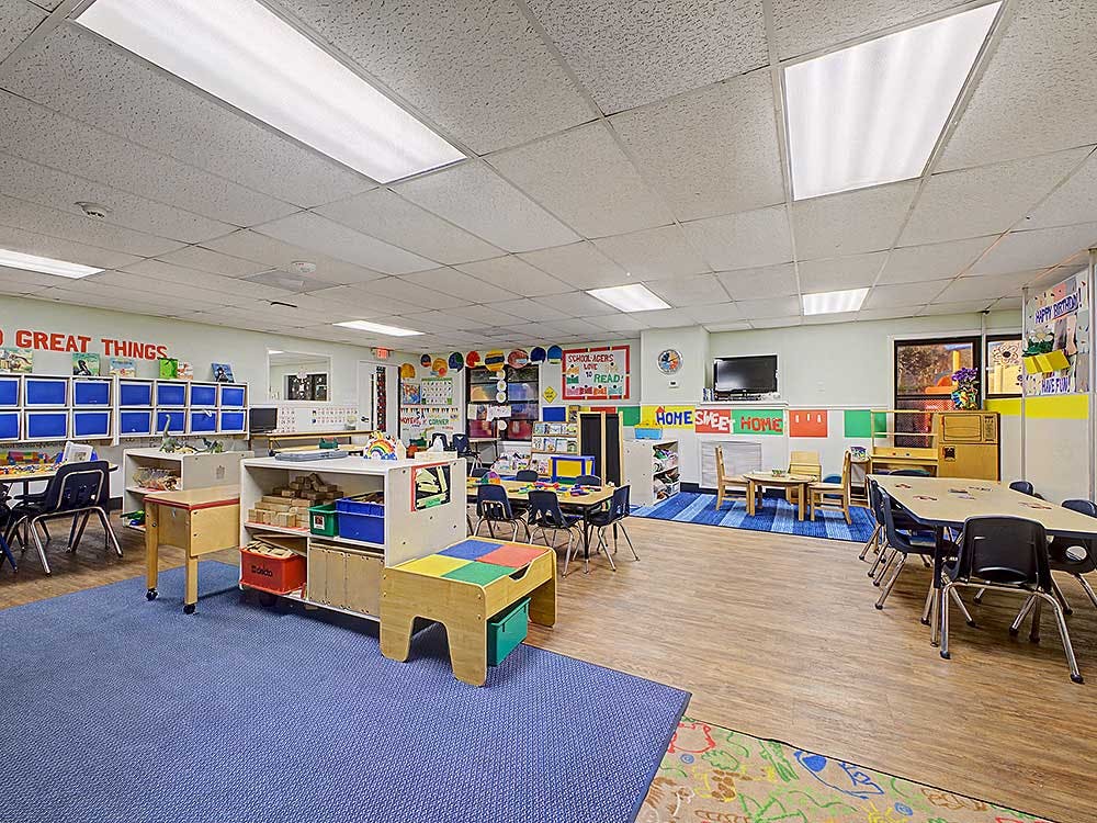 Colorful classroom with various tables, chairs, and learning materials