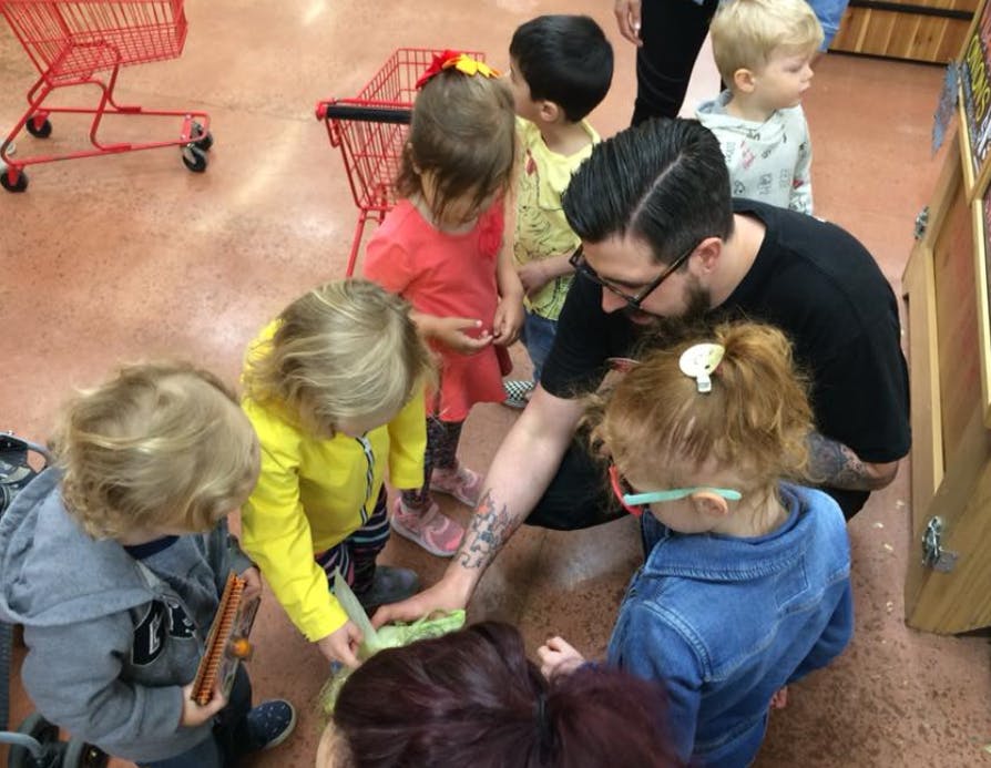 Adult and children looking at an item on the floor
