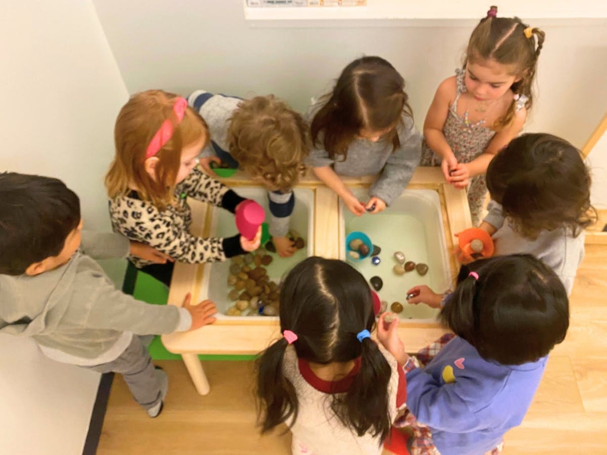 Children playing at a water table with toys