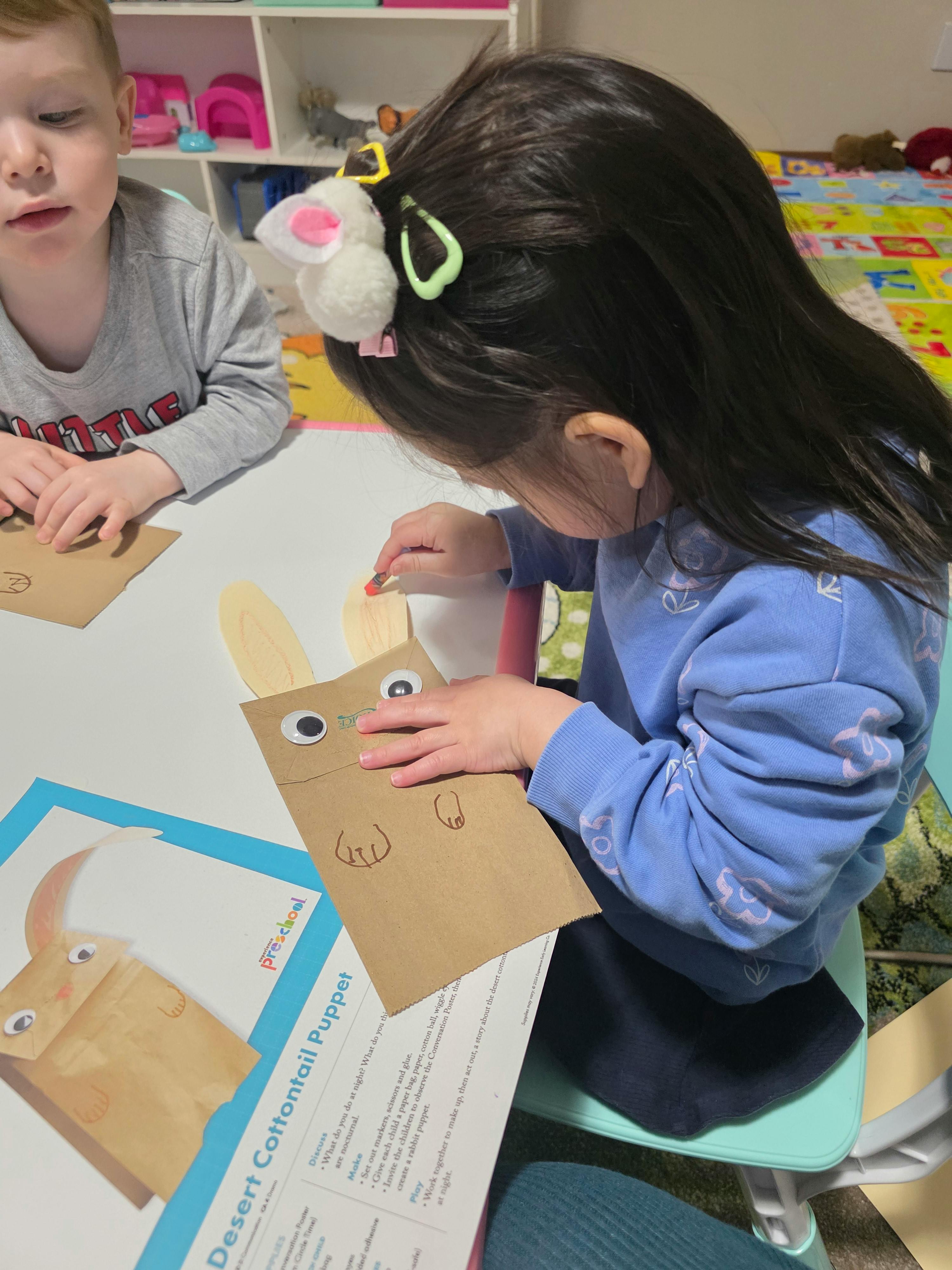 Child making a paper bag puppet