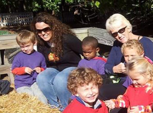 Two adults and five children sitting outdoors