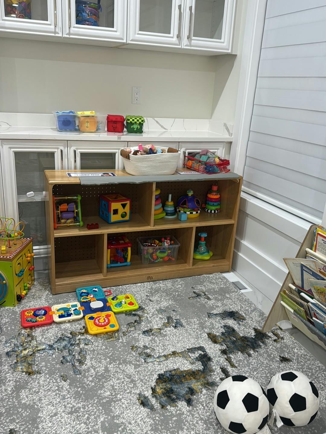Wooden toy shelf with activity toys on a playroom floor