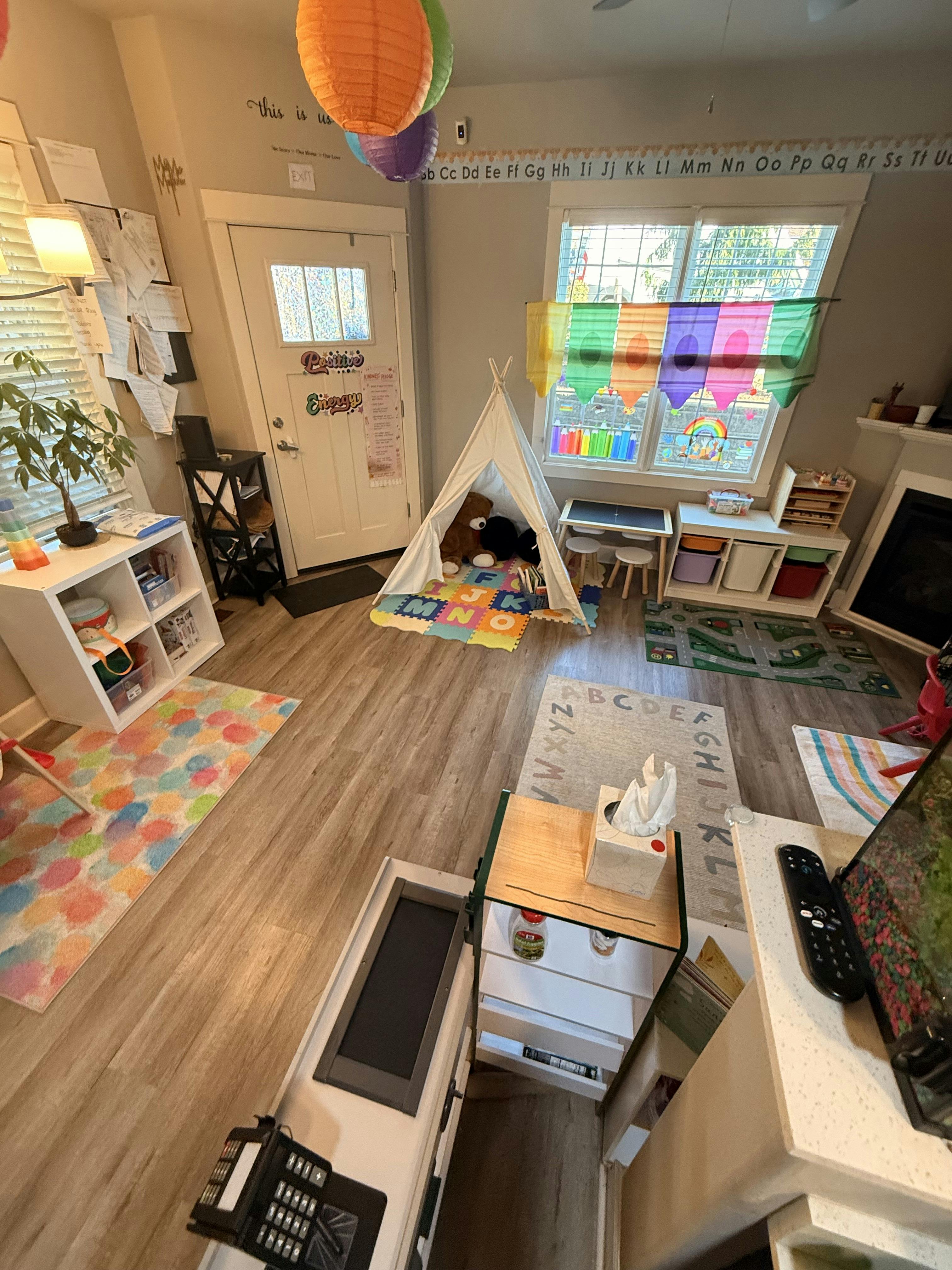 Child's playroom with a teepee, alphabet rug, and colorful decorations