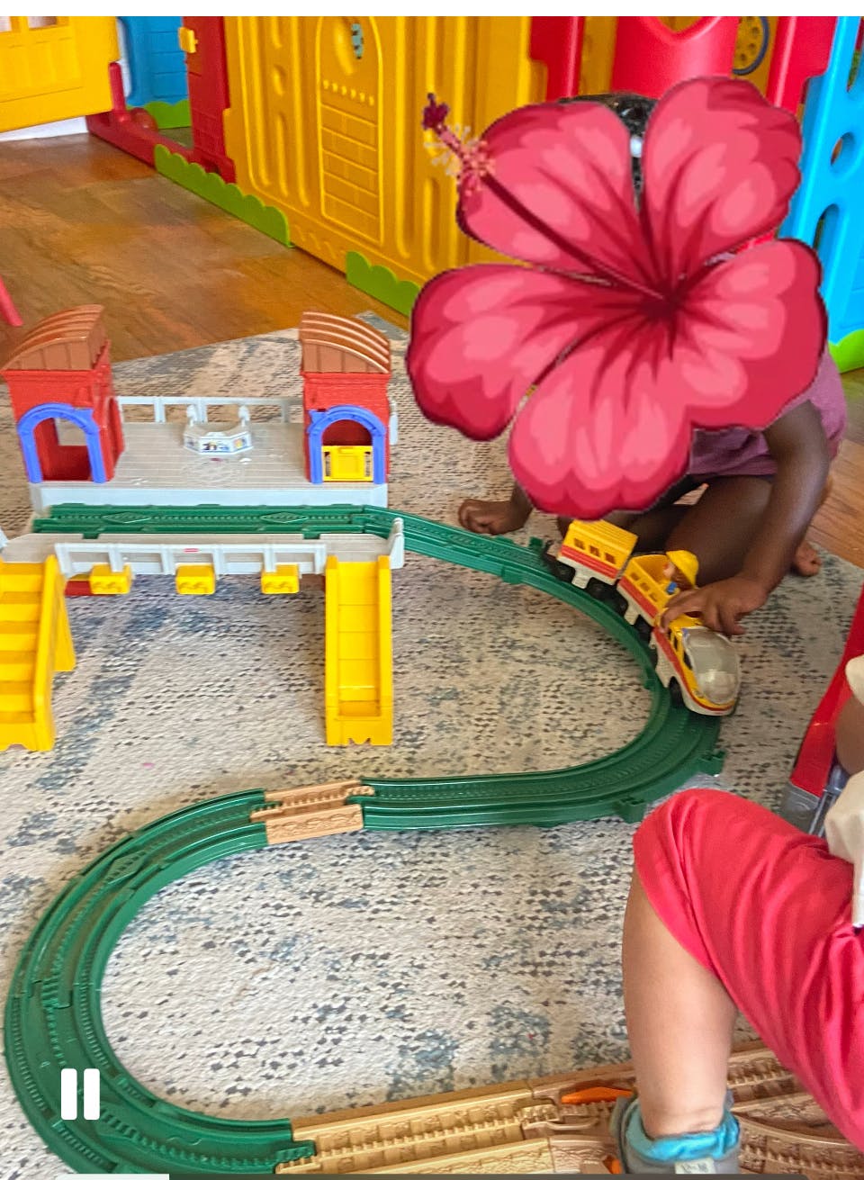 Child playing with a toy train set on a play mat