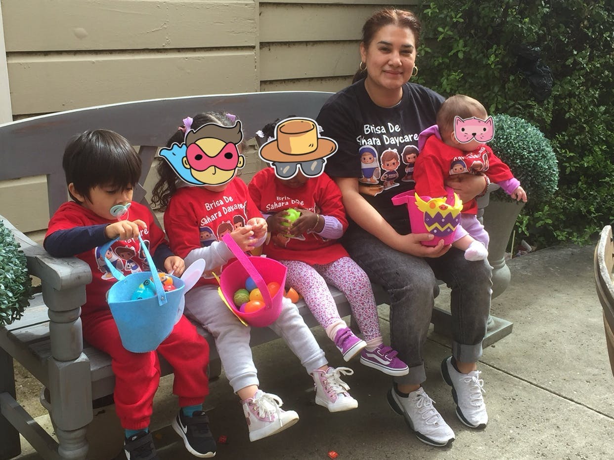 Person holding a child, with three other children holding baskets
