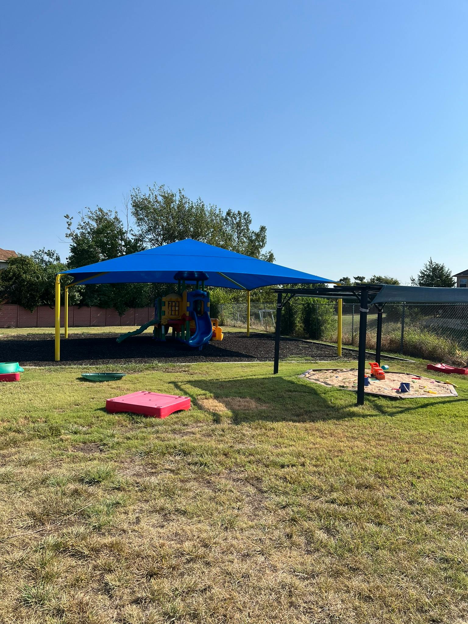 Playground with blue shade structure and sandpit
