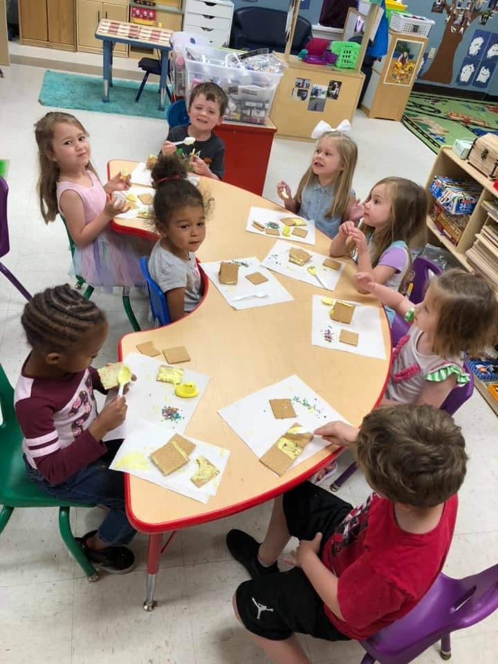 Children sitting at a table doing an art activity