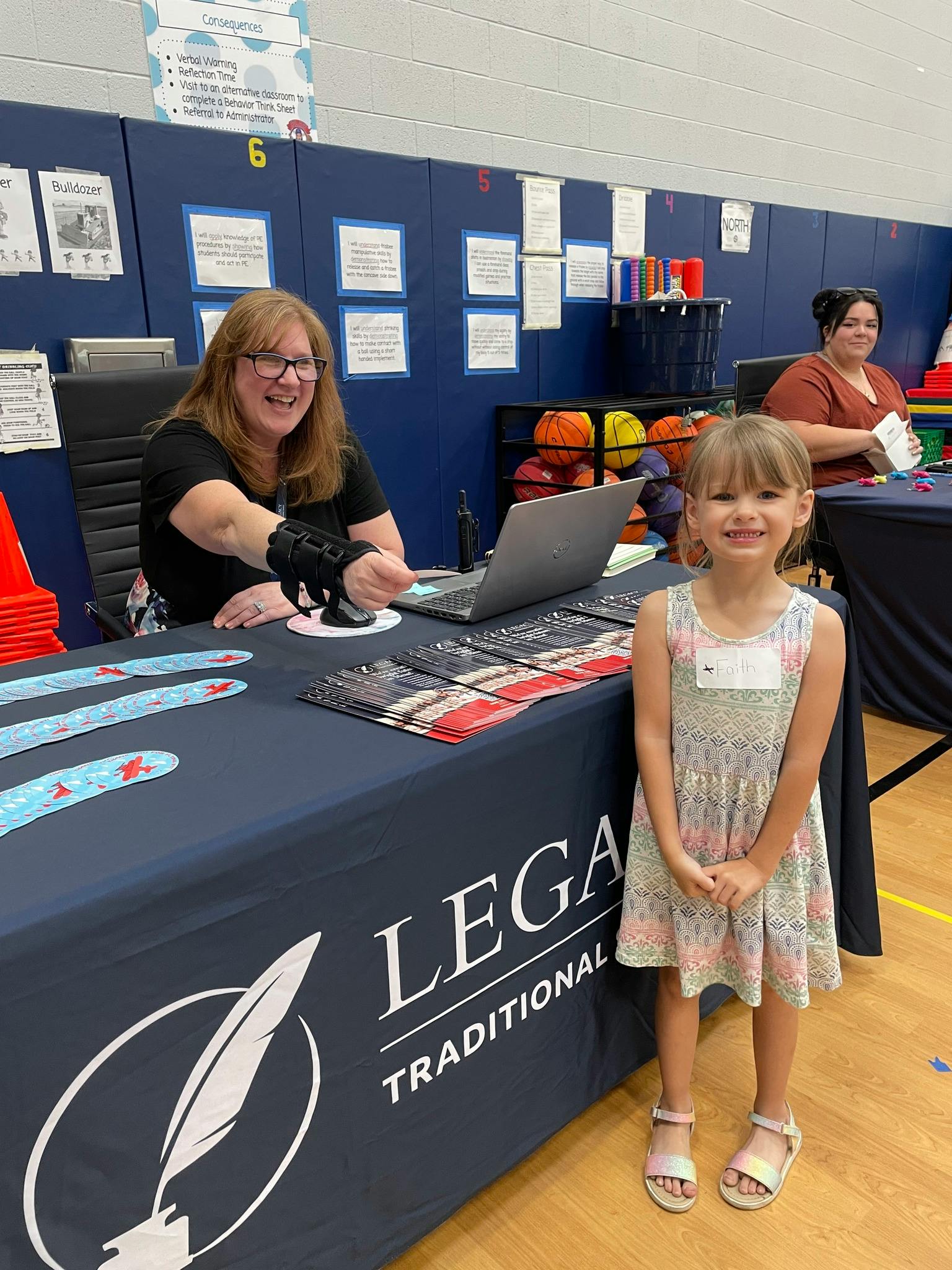 Adult at table with laptop and child standing in front