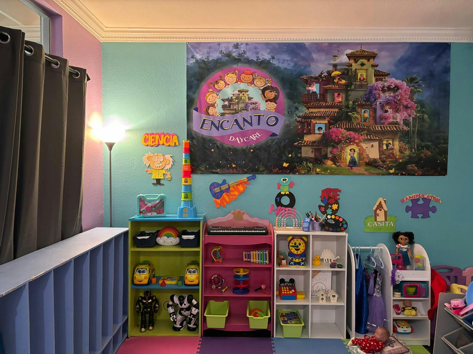 Children's room with toy shelves and a large Encanto poster on the wall