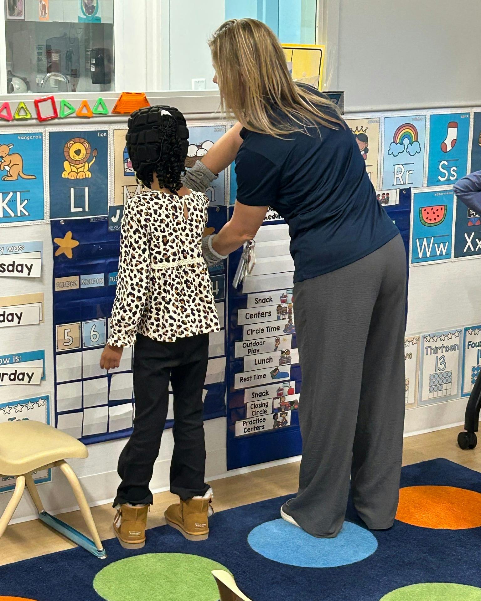 Adult and child standing in a classroom
